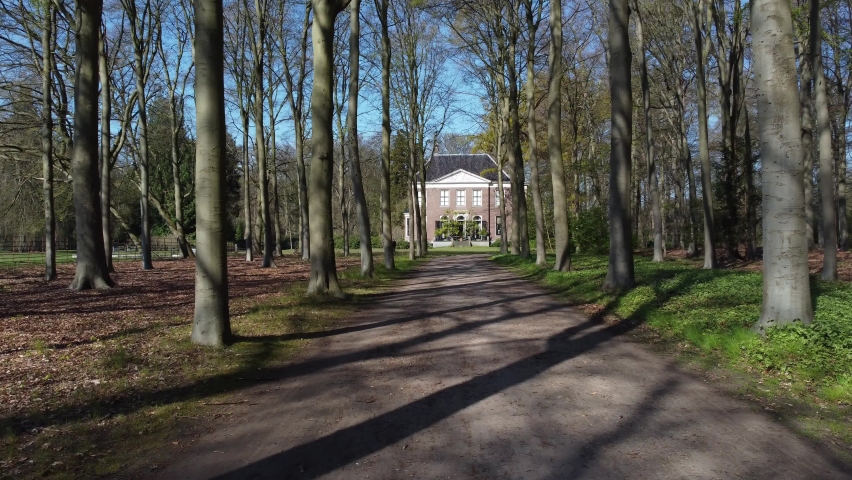 Forest symetrical lane to landhouse, forward aerial shot