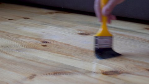 paint the wooden floor with a brush,varnishing the wooden floor of the House