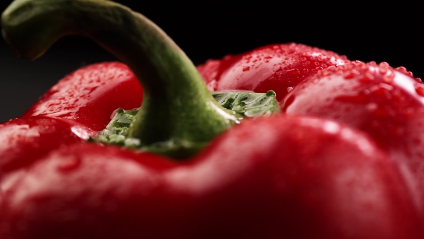 Wet red bell pepper rotates on black background. Macro. Royalty-Free Stock Footage #1071764335