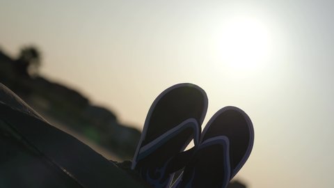 Two flip flops in the backlight at sunset