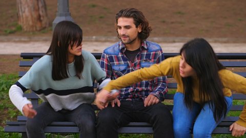 female complicity - young man is excluded from the conversation by two friends 