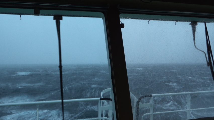 View from ship's bridge. Storm. Ship is rocking. High waves. White foam on the water. Windshield wiper works. Royalty-Free Stock Footage #1071769192