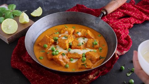 Woman hand serving paneer butter masala , Paneer tikka masala curry Delhi Mumbai North Indian vegetarian side dish butter paneer made using cottage cheese, Indian spices 4K slow motion video, footage