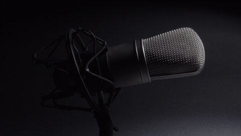 Professional studio microphone on an anti vibration stand, being side lit.