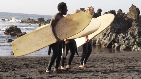 Multiracial surfer people dancing with music at the beach - Multi generational men and extreme water sport concept