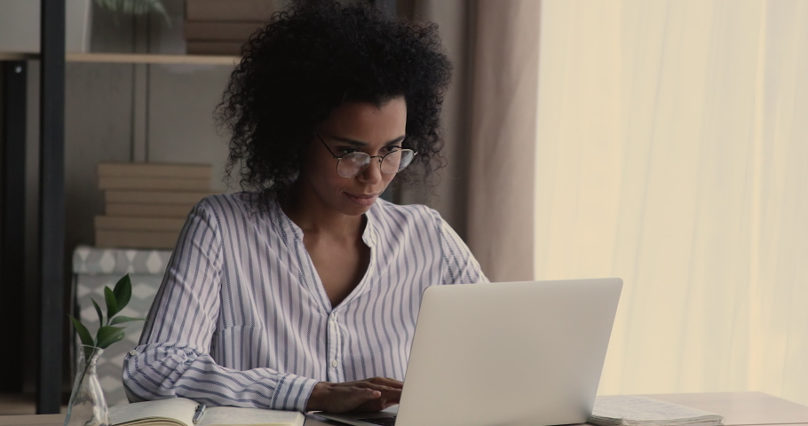 African woman sit at desk studying on computer takes off glasses experiences weak blurred vision due long working on laptop without break, need eyesight surgery, laser eye vision correction concept Royalty-Free Stock Footage #1071788572