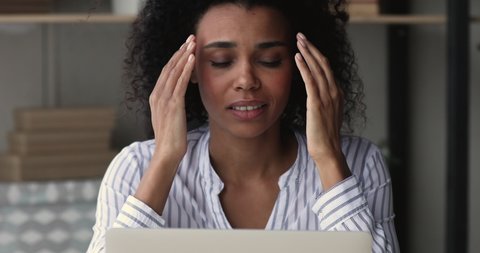 African woman working on laptop feels stressed about system virus, important data loss, outraged with website mistake, close up. Slow and stuck computer, malware, broken device, need repair concept