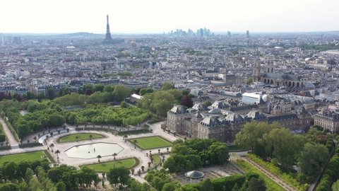 France, Paris, Luxembourg Gardens and Palais (French Senate) with Eiffel Tower in back, backward drone aerial view