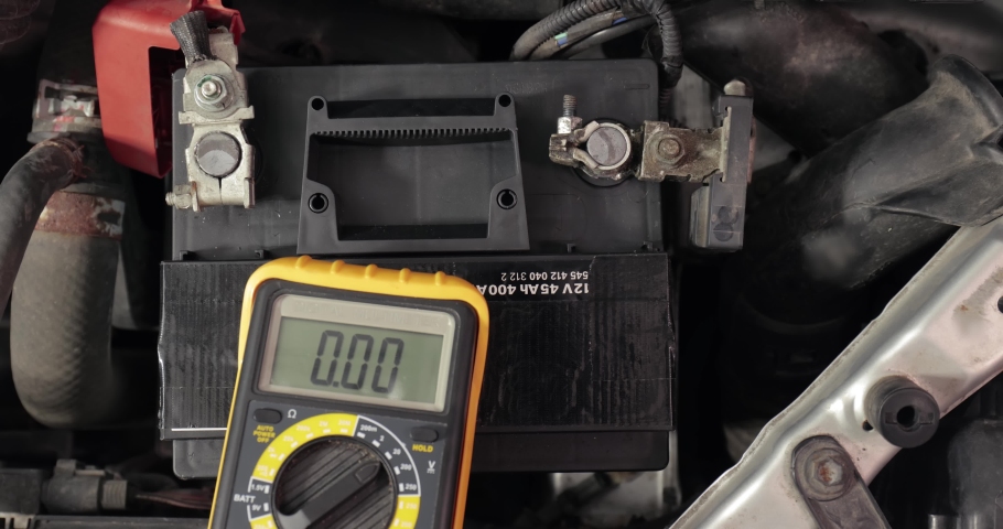 Car starter battery. Check battery voltage with electric multimeter. Good, electrician thumbs up, battery charged fully | Shutterstock HD Video #1071794659