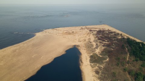 Aerial top down of sandy beach ans coastline in Gdansk and calm Baltic Sea in backdrop.