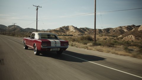 Old Mustang Car driving on Scenic Highway in California surrounded by Desert, Tracking follow shot, Palmdale, California in 2019