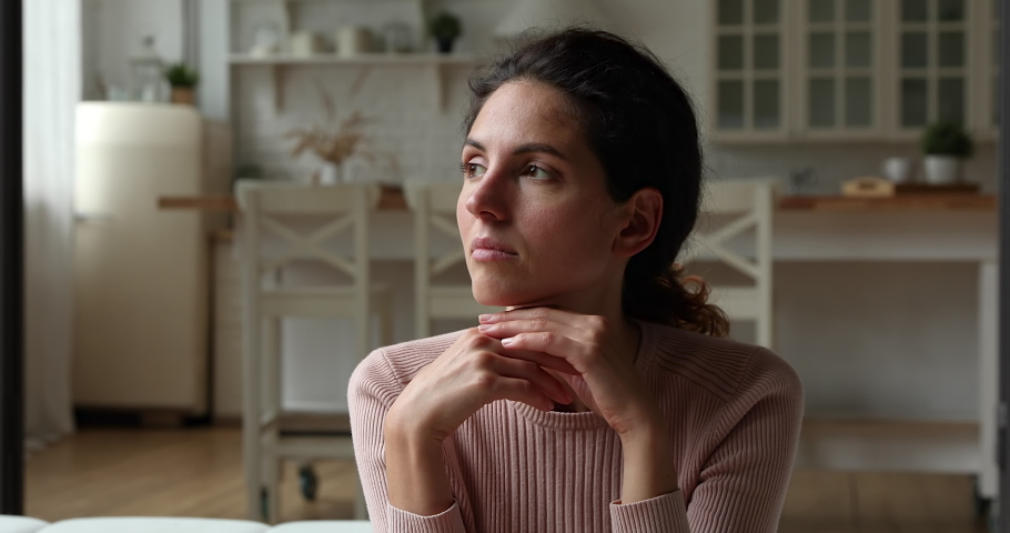 Sad thoughtful young single woman thinking of personal problems life troubles feels lonely. Female absorbed in sad thoughts, pass through divorce or break up. Unwilling pregnancy and abortion concept | Shutterstock HD Video #1071802621
