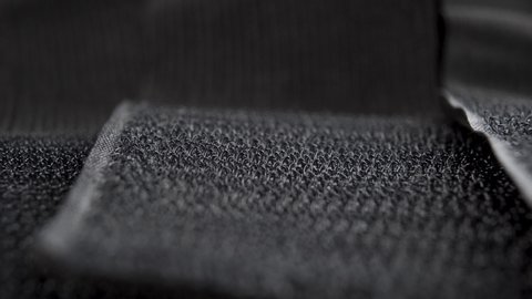 Black abstract texture of hooked velcro on fastening tapes. Macro. Dolly shot. Selective focus