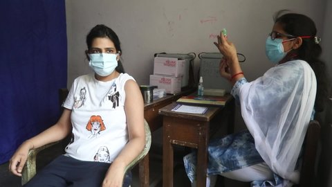 New Delhi, India, May 04, 2021: A nurse administers a dose of Oxford-AstraZeneca's coronavirus COVID-19 vaccine Covishield to a woman during the second wave of coronavirus at a vaccination center.