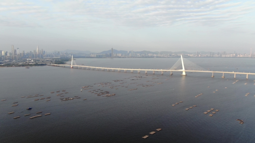 Hong Kong Shenzhen Bay Bridge with Tin Shui Wai buildings in the horizon and Fish and Oyster cultivation pools, Aerial view.