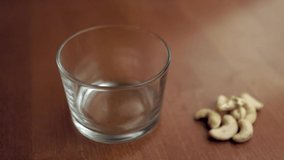 Cashew nuts falling in the glass