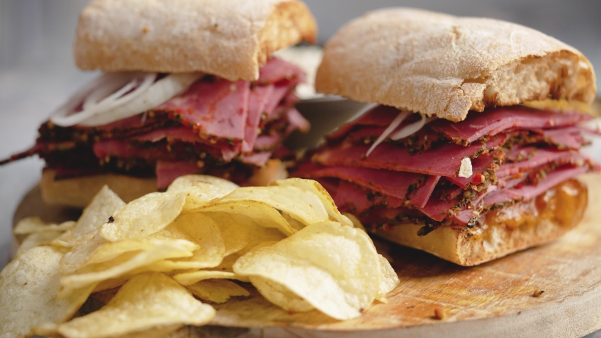 Pastrami sandwhich with delicious meet on baguette bread with chedder cheese, onion