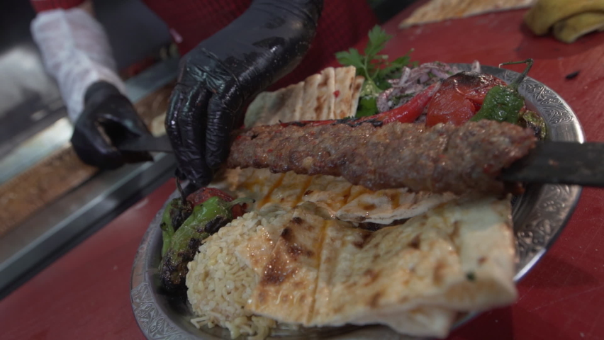 Traditional Turkish shish kebab and vegetables on barbecue fire. Turkish Adana kebab, ciger kebab on fire with smoke.