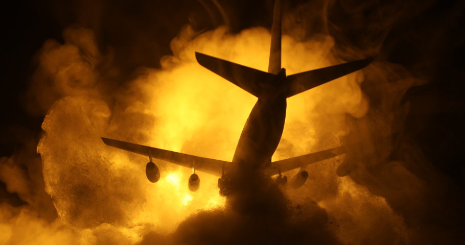 Air Crash. Burning falling plane. The plane crashed to the ground. Decorated with toy at dark fire background. Air accident concept. Selective focus