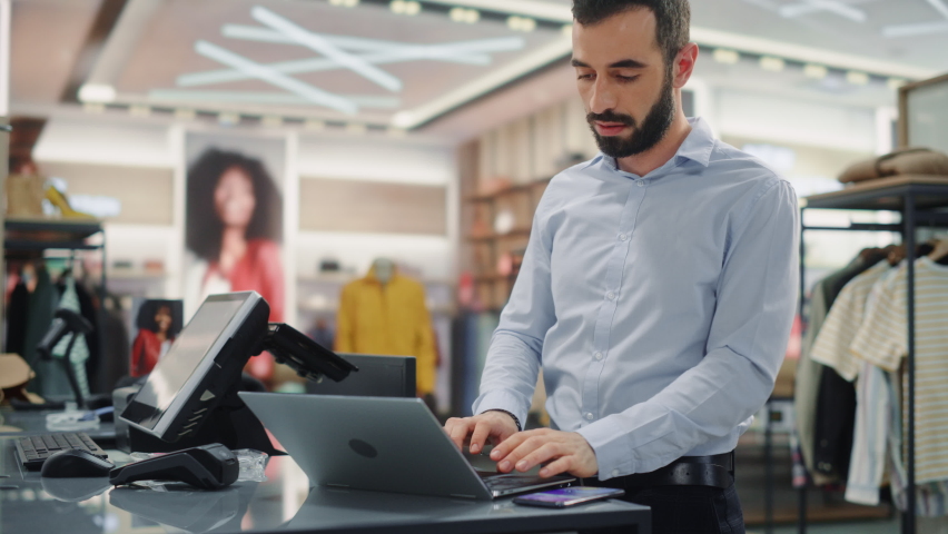 Modern Clothing Store: Friendly Customer Support Specialist Talks to Client on the Smartphone. Smiling Retail Sales Manager or Young Designer Contacts Client about Online Order in Fashion Shop | Shutterstock HD Video #1071832234