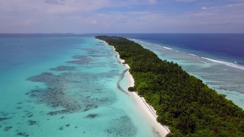 Island in Maldives. Aerial video of a drone flying over a paradise white sand beach