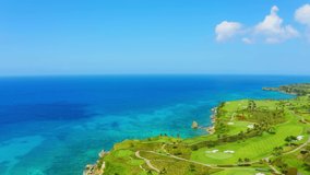 Golf course aerial 4k view stock video footage. Bright glade with green grass and Caribbean sea landscape. Beautiful planet earth top view.