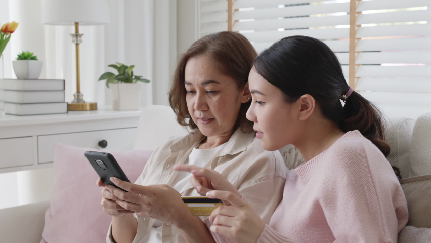 Asian family people satisfaction pay or transfer money online tech in living room sofa couch in social commerce shop promotion, urban life omni channel fintech connect in diverse generation concept. | Shutterstock HD Video #1071839914