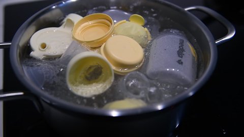 Paris, France - Circa 2021: Close-up of multiple Medela breast pumps accessories boiling hygienic process of boiling water