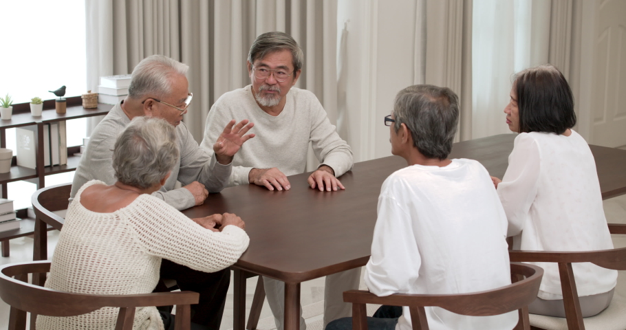 A Group of happy Asian seniors male and female sitting in cozy common room and sharing their experience with a smile at nursing home. Elderly men and women spending free evening together indoors. Royalty-Free Stock Footage #1071843289