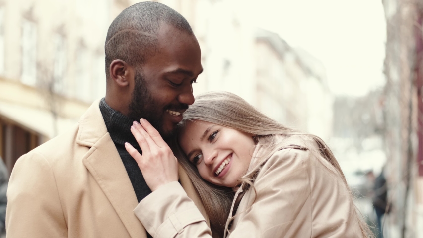 Affectionate young woman hugging her boyfriend in the city