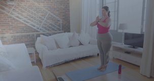Animation of network of connections over woman practicing yoga at home. global sports, fitness and active lifestyle concept digitally generated video.