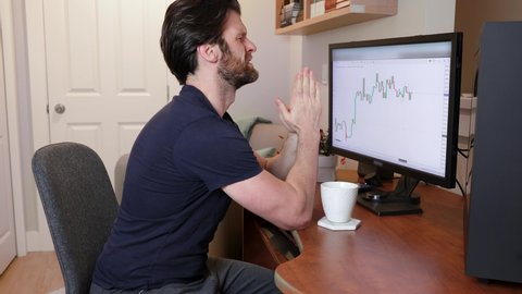 Man looking at finance chart on computer stressed out, praying and wishing for the market to go up and not crash. 4K 24FPS