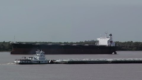 Rosario, Santa Fe province, Argentina - March 2020: Bulk Carrier and Boat Towing a Grain Barge near the City of Rosario, Santa Fe province, Argentina.  