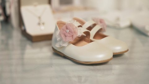 Baptism concept. Pink baby girl shoes with flowers. Close up detail shot