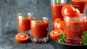 Tomatoes and a glass of tomato juice are spinning on the crumbling table. Healthy food concept. High quality FullHD footage