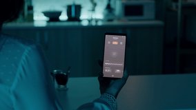 Woman sitting in house with automation light system holding smartphone turning on light using voice activated application. Person controlling room ambiance and energy efficiency with smart home app - Powered by Shutterstock - Get 15% off with code: PIKWIZARD15