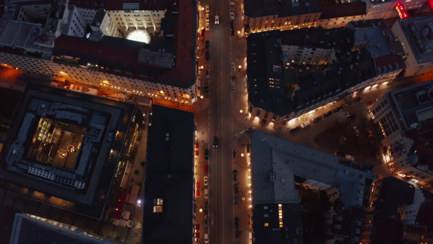 Flight over typical Neighborhood in Munich, Germany beautiful Winter Vibe at Night with City Lights and traffic glowing, Aerial Birds Eye Overhead Top Down View Royalty-Free Stock Footage #1071872041