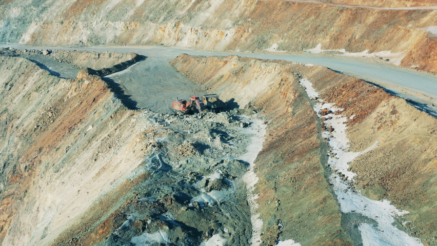 Top view of an excavator working in the copper mine. Open quarry, mining industry concept.