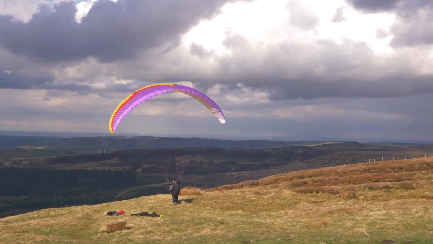 Paragliding pilot on high landscape waiting take off wide shot | Shutterstock HD Video #1071879607