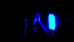 Blurred video of Young man in glasses and headphones on the night party in nightclub with neon lights. Have fun tonight. Holidays entertainment.