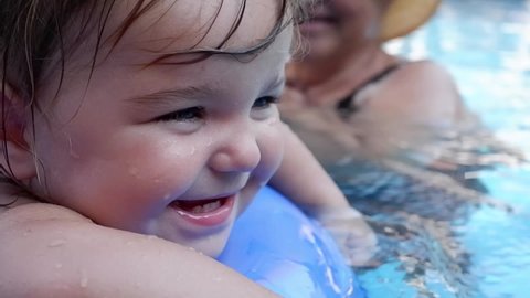 Cute baby whirling in a swimming circle in the pool