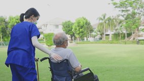 Asian young woman nurse support disabled senior elderly man on wheelchair to walk with cane at park. Caregiver doctor and older mature handicapped patient wear mask to prevent from Covid-19 pandemic. - Powered by Shutterstock - Get 15% off with code: PIKWIZARD15