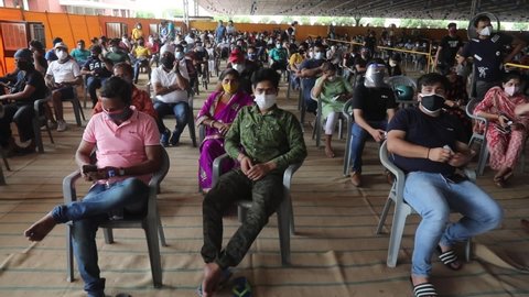 New Delhi, India, May 5, 2021: People wearing face mask wait for the dose of the coronavirus (COVID-19) vaccine, Covishield manufactured by Serum Institute of India, at Covid-19 vaccination center.  