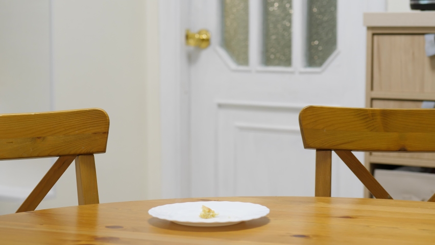 Dog steals piece of food left on the table when no one looking. Beagle stand up on hind legs, use front paw to pull plate to edge and pick up little leftover or snack, barely chew and swallow it Royalty-Free Stock Footage #1071905707