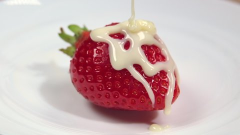 Strawberries are poured with condensed milk