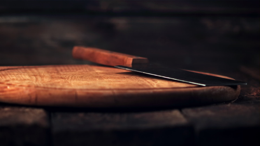 Super slow motion sliced into thin pieces of ham falls on a cutting board with a knife.Filmed at 1000 fps. On a wooden background.  | Shutterstock HD Video #1071906796