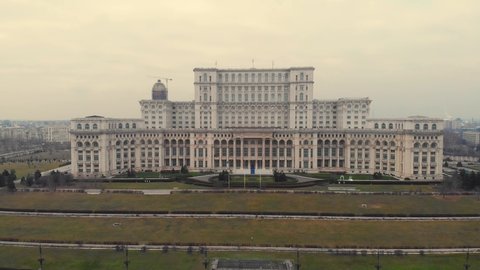 Aerial Cinematic footage clip: Drone flying over The Palace of the Parliament, Unirii Boulevard and Constitutiei square in Bucharest, Romania. the second largest building, built built by Ceausescu