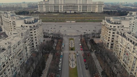 Aerial Cinematic footage clip: Drone flying over The Palace of the Parliament, Unirii Boulevard and Constitutiei square in Bucharest, Romania. the second largest building, built built by Ceausescu