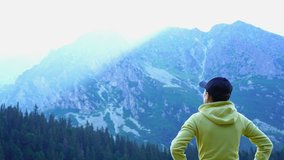 Female tourist uses a smartphone to video a beautiful view in the mountains, Popradske mountain lake, Slovakia, High Tatras