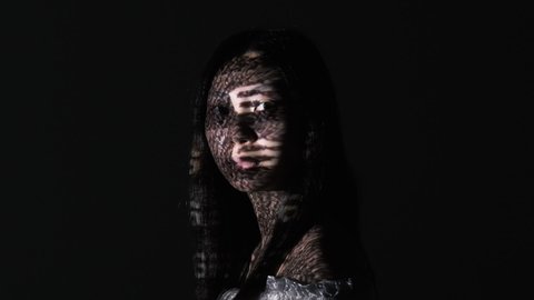 System error. Memory loss. Mental disorder. Amnesia brain damage. Confused puzzled glitched Asian woman face in dark analog VHS noise motion projector light isolated on black.